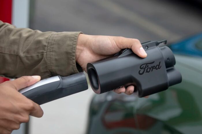 Una foto de un Supercargador Tesla enchufado a un adaptador de corriente Ford.